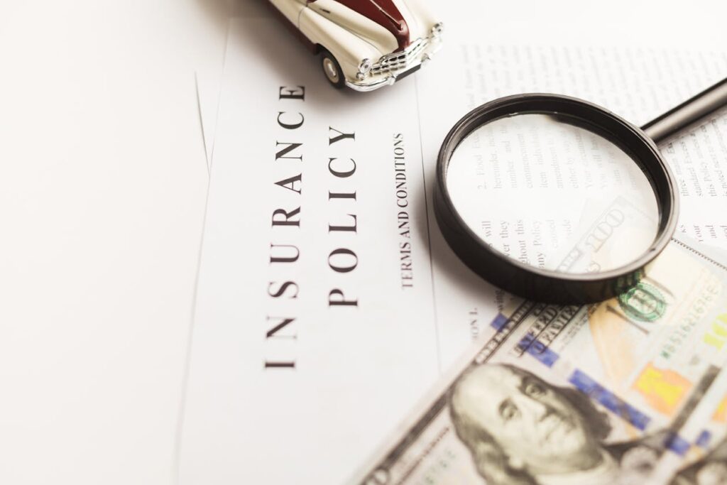 Insurance policy document under magnifying glass with car and money representing financial responsibility law